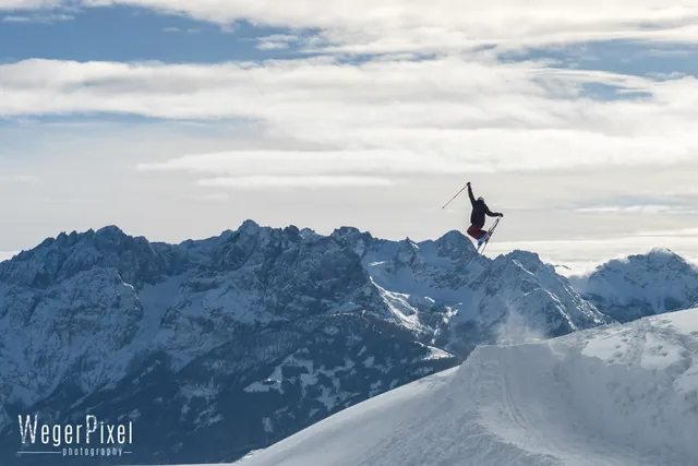 Freeskierin springt am Zettersfeld vor dem Panorama der Lienzer Dolomiten
